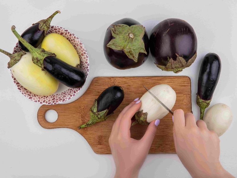 Skinless eggplant on a cutting board with the skin beside it, showing how to prepare eggplant safely for dogs