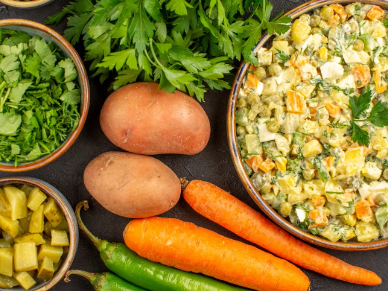 A mix of healthy vegetables like green beans, spinach, sweet potatoes, and carrots arranged in a neat bowl.